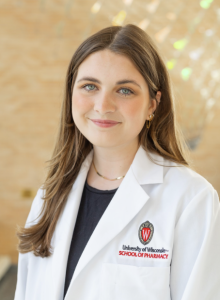 A woman wearing a white Wisconsin School of Pharmacy coat. 